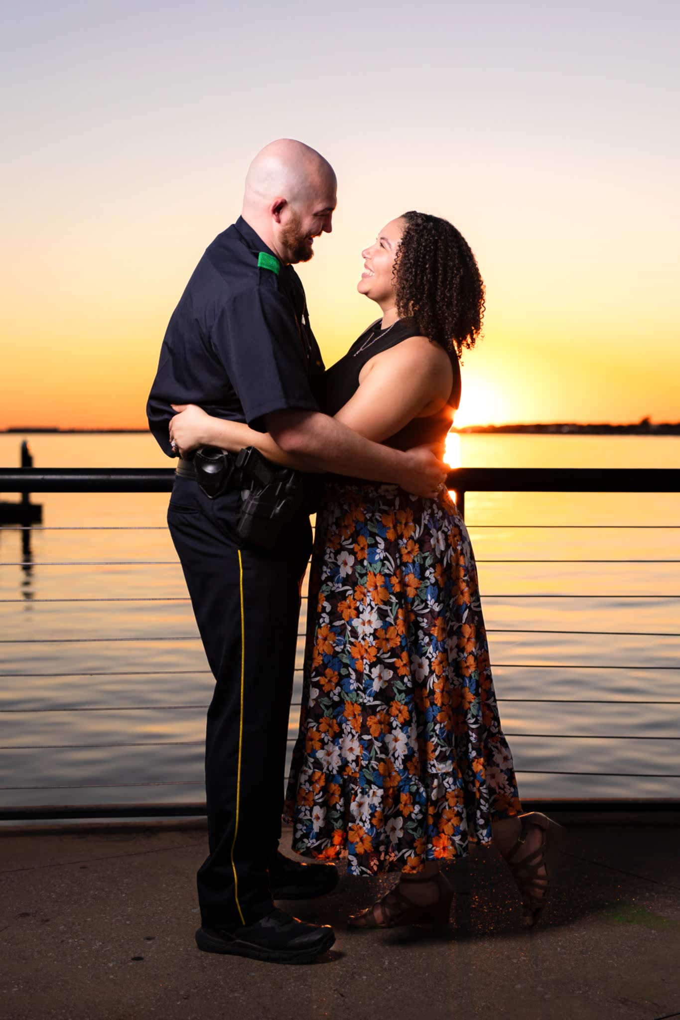 engaged couple hugging at sunset by lake in Rockwall